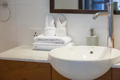 a bathroom with a sink and towels on a counter at Villa CJ Seminyak in Seminyak