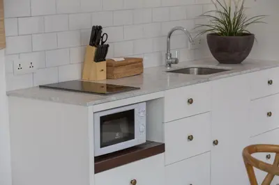 a kitchen counter with a sink and a microwave at Villa CJ Seminyak in Seminyak