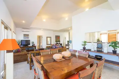 a living room with a wooden table and chairs at Beach Melati Apartments in Legian