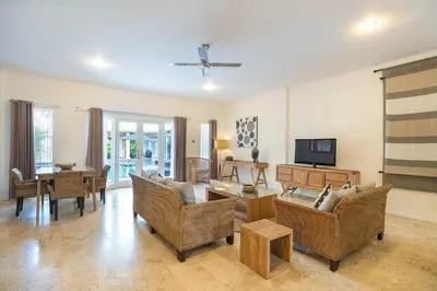a living room with a couch and a tv at Beach Melati Apartments in Legian