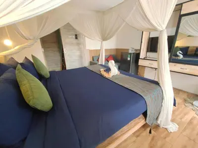 a blue bed with a stuffed animal on top of it at Kubu Guest House in Seminyak