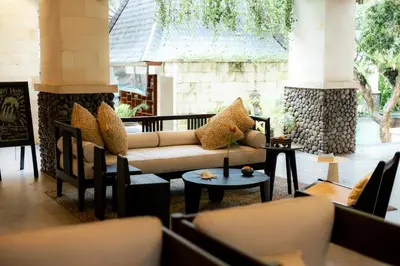 a living room with a couch and tables and chairs at Fourteen Roses Beach Hotel in Legian