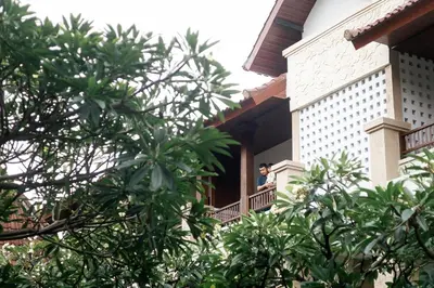 a man standing on a balcony of a building at Fourteen Roses Beach Hotel in Legian