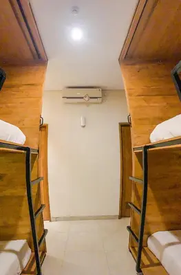a room with three bunk beds in a room at DBeds Kuta Beach in Kuta