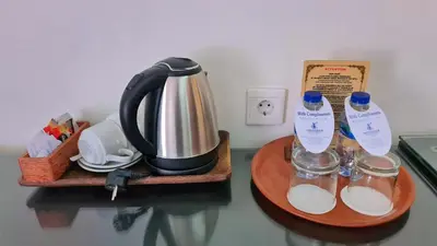a table with a coffee maker and a tea kettle at Satriya Cottages in Kuta