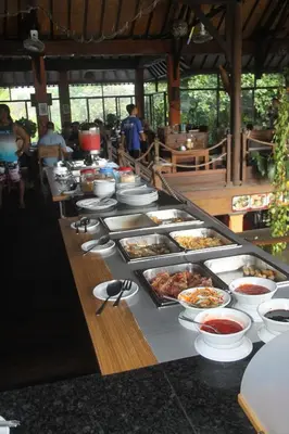 a buffet line with many plates of food on it at Satriya Cottages in Kuta