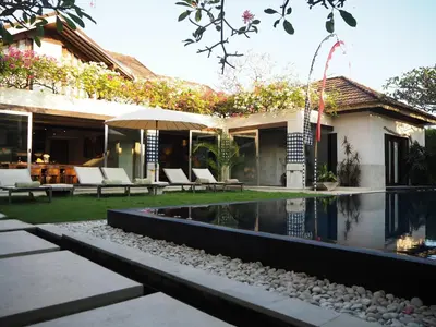 a house with a swimming pool in the yard at Pronoia Beach Resort in Jimbaran