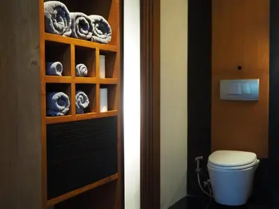 a bathroom with a toilet and a shelf with cookies at Pronoia Beach Resort in Jimbaran