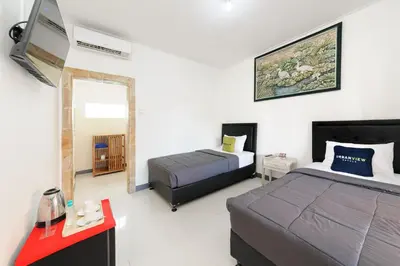 a bedroom with a bed and a desk and a bed sidx sidx sidx at Urbanview Hotel Rasa Sayang Inn Tanjung Benoa Bali in Nusa Dua