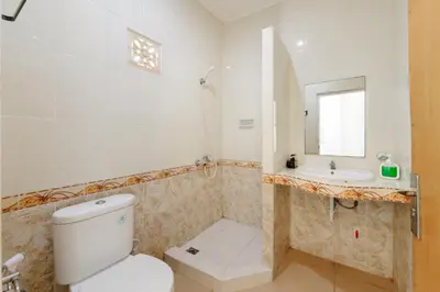 a bathroom with a toilet and a sink at Urbanview Hotel Rasa Sayang Inn Tanjung Benoa Bali in Nusa Dua