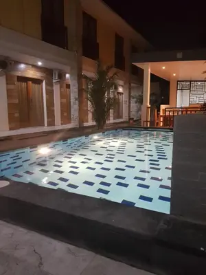 a swimming pool in a hotel at night at Praba Guesthouse in Kuta