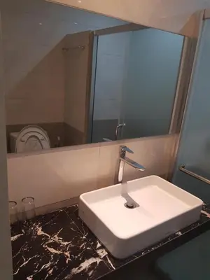 a bathroom with a white sink and a mirror at Praba Guesthouse in Kuta