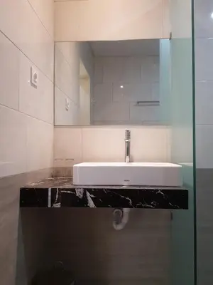 a bathroom with a sink and a mirror at Praba Guesthouse in Kuta