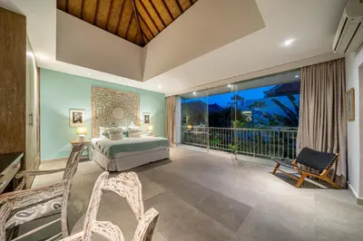 a bedroom with a bed and a balcony at Villa Jekumah 3 in Seminyak