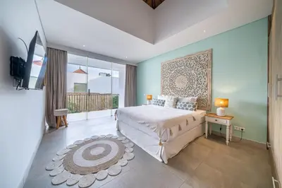a bedroom with a large bed and a balcony at Villa Jekumah 3 in Seminyak