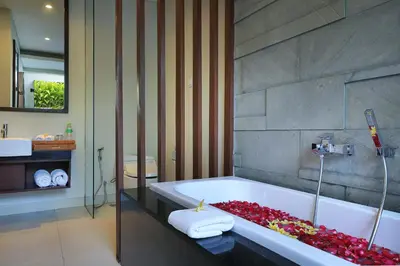 a bathroom with a tub filled with red flowers at Samaja Beachside Villas in Seminyak