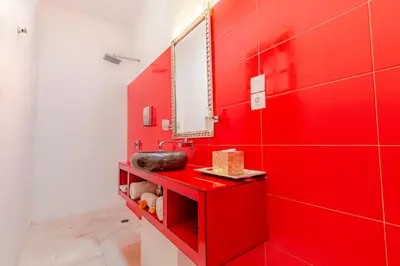 a red bathroom with a sink and a mirror at Bali Ginger Suites & Villa in Seminyak