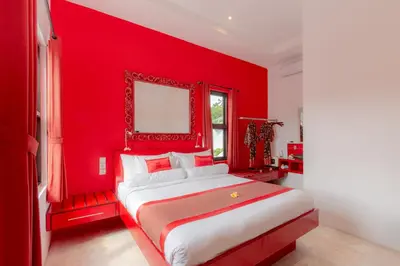 a red bedroom with a bed with a red wall at Bali Ginger Suites & Villa in Seminyak