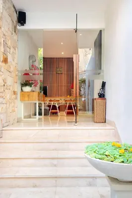 a living room with a wooden floor and a table at The Jimbaran Villa by Ini Vie Hospitality in Jimbaran