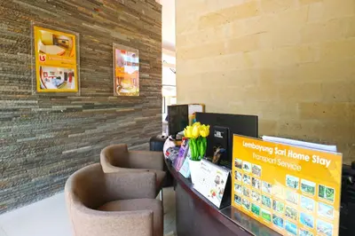 a waiting room with two chairs and a counter with flowers at Lembayung Sari Homestay in Denpasar