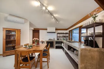 a large kitchen with a wooden table and chairs at Best Location 7 Bed, 7,5 Bath Pool Villa, near beach in Kuta