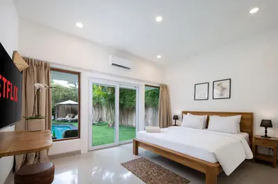 a bedroom with a bed and a large window at Best Location 7 Bed, 7,5 Bath Pool Villa, near beach in Kuta
