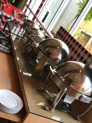 a row of sinks in a glass counter with plates at Ibis Bali Kuta in Kuta