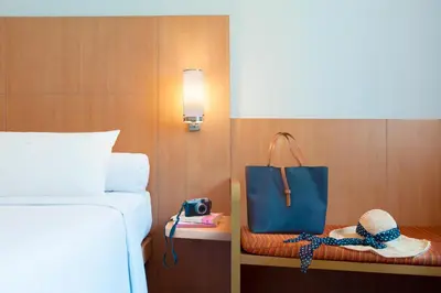 a hotel room with a bed and a blue bag at Ibis Bali Kuta in Kuta