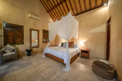 a bedroom with a bed with a canopy at Rumi Villas in Seminyak