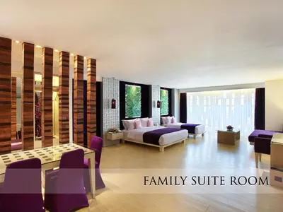 a family suite room with a bed and a couch at Grand Mega Resort & Spa Bali in Kuta