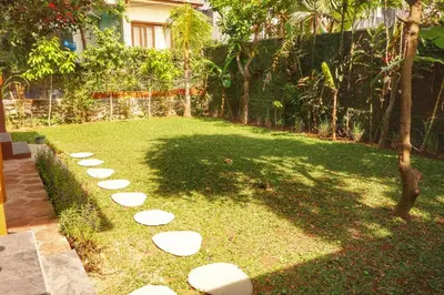 a garden with white stepping stones on the grass at Petit Tree in Seminyak