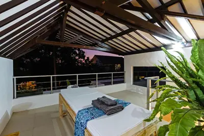 a room with a bed and a balcony with windows at Villa Serasi in Canggu