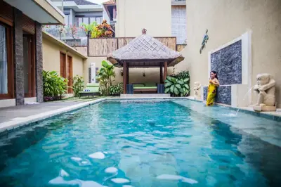 a woman standing in front of a swimming pool at O Villas Seminyak in Seminyak