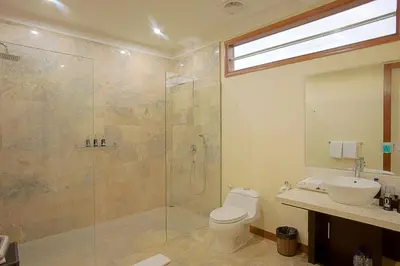 a bathroom with a shower and a toilet and a sink at O Villas Seminyak in Seminyak