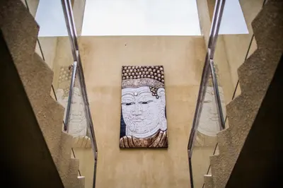 a staircase with a picture of a statue on the wall at O Villas Seminyak in Seminyak