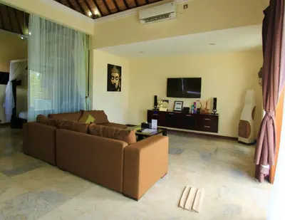 a living room with a brown couch and a tv at O Villas Seminyak in Seminyak