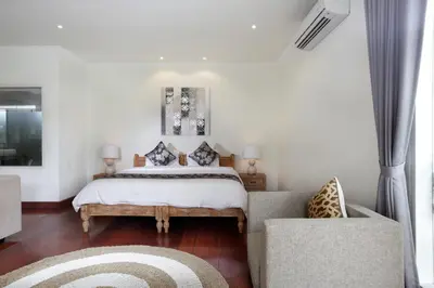 a bedroom with a bed and a couch at Villa Marronniers in Seminyak