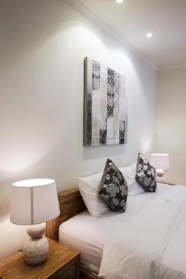 a bedroom with a bed and a table with a lamp at Villa Marronniers in Seminyak