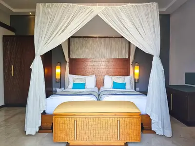 a bedroom with a canopy bed with blue pillows at Seminyak Icon - by Karaniya Experience - CHSE certified in Seminyak