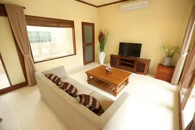 a living room with a couch and a table and a tv at Villa Chambertin in Seminyak