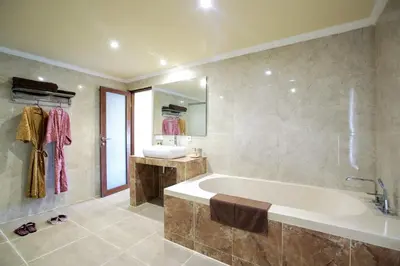 a large bathroom with a tub and a sink at Villa Chambertin in Seminyak