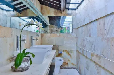 a bathroom with two sinks and a toilet at Villa Champagne in Seminyak