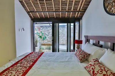 a bedroom with a large bed and a window at Villa Champagne in Seminyak