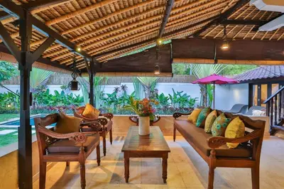 a living room with a couch and chairs and a table at Villa Champagne in Seminyak