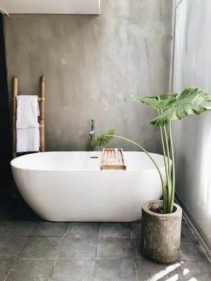 a bath tub in a bathroom with a potted plant at Lloyd's Inn Bali in Seminyak