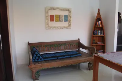 a bench in a room with a picture on the wall at Jukung Villas Kuta in Kuta