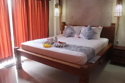 a bedroom with a large bed with pillows at Jukung Villas Kuta in Kuta