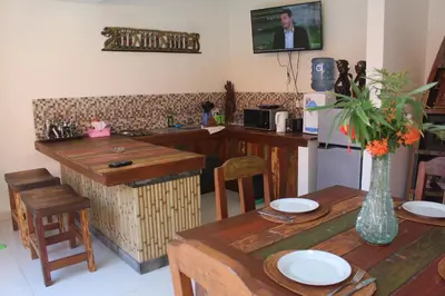 a kitchen with wooden tables and a counter with a table sidx sidx sidx at Jukung Villas Kuta in Kuta