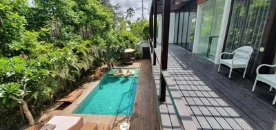 a swimming pool on a balcony with a house at Beach Axis Villa, Seminyak in Seminyak
