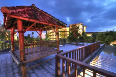 a wooden gazebo with a building in the background at Beach Axis Villa, Seminyak in Seminyak